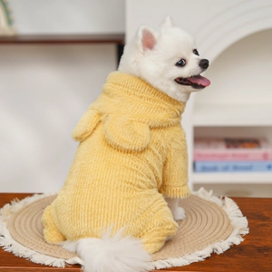 Gilet giallo per animali in velluto con orecchie mostrato su un cucciolo bianco in interni