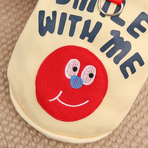 Close-up of red cartoon character patch and blue lettering on beige canvas pet apparel