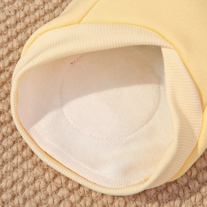 Close-up of yellow dog sweater detail featuring warm fleece lining and ribbed cuffs