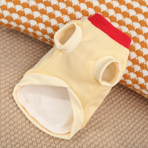 Detail of warm yellow pet vest with red collar stitching and ribbed elastic cuffs