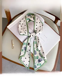 Close-up of elegant polka dot silk scarf with gingko leaf print on art magazine