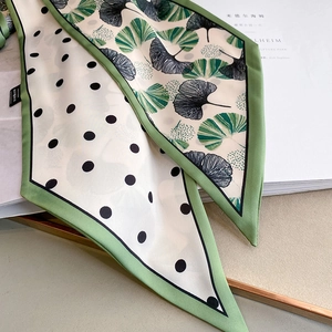 Polka dot and green ginkgo leaf silk skinny scarf on aesthetic magazine display