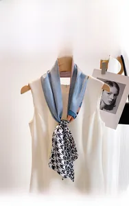 Close-up of narrow silk scarf with patchwork of houndstooth, leopard print and blue panels