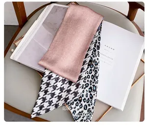 Detail of multi-pattern silk scarf featuring houndstooth and leopard print patchwork texture