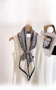 Detail of houndstooth silk scarf with letter pattern on white sleeveless dress