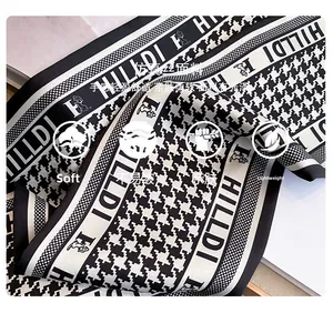 Macro detail of houndstooth silk-like scarf with soft texture and elegant drape