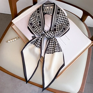 Detail of black and white houndstooth silk scarf with letter print on a fashion magazine