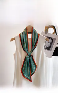 Détail d'un foulard en soie vert vintage à fleurs noué sur une robe blanche élégante