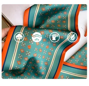 Détail d'un foulard en soie imitation avec imprimé floral vintage et bordure orange