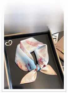 Détail d'un foulard en soie avec motif de peinture à l'huile et boucle de bague en diamant