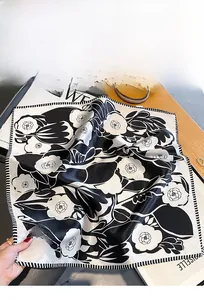 Dettaglio di un foulard in 100% seta di gelso con stampa camelia vintage e bordo a righe