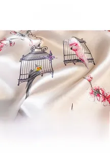 Detail showing high-quality silk scarf fabric with floral, bird cage, and butterfly patterns