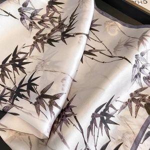 Écharpe élégante en soie avec imprimés de feuilles de bambou sur tissu blanc cassé