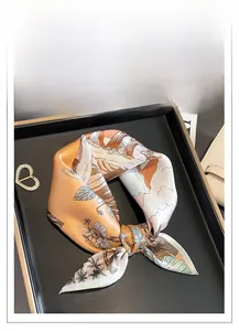 Detail of silk square scarf with floral print, heart buckle and luxury tray