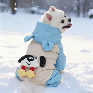 Detail of blue and beige waterproof hooded dog winter coat with cartoon patch in snow