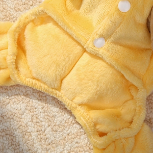 Makro-Detail von weicher gelber Fleece-Tierkleidung mit hochwertigen Druckknöpfen
