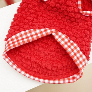 Detail of red plush pet coat featuring soft faux fur texture and gingham hem piping