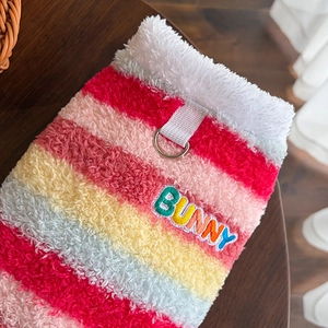 Gros plan d'un pull rayé coloré pour chien avec polaire chaude et anneau en D en métal