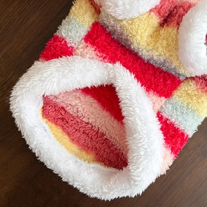 Détail d'un vêtement arc-en-ciel pour animaux avec texture pelucheuse et col blanc doux