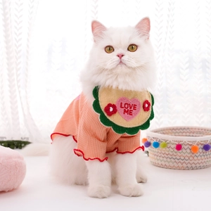 Détail d'un bavoir tricoté pour chat avec broderie LOVE ME et bordures de fleurs