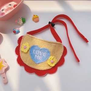 Détail du bavoir tricoté pour animaux avec dentelle rouge et broderie LOVE ME en cœur