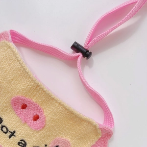 Gros plan sur un bandana tricoté pour animaux avec broderie cochon et cordon réglable