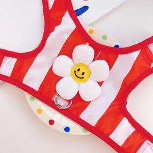 Detail of red striped pet harness vest featuring a plush sunflower and metal D-ring