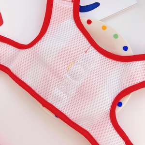 Close-up of red and white breathable mesh fabric on dog harness with honeycomb texture