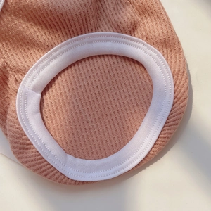 Macro view of peach waffle knit pet vest showing white elastic edging and soft texture