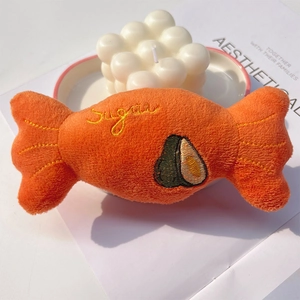Close-up of plush orange candy toy with Sugar embroidery and avocado pattern for pets