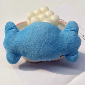 Close-up of a blue candy-shaped plush squeaky toy for dogs and cats on a white desk