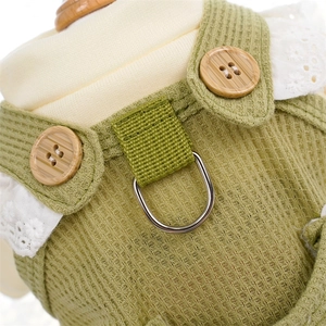 Detail der grünen Waffelstoff-Haustierweste mit Holzknöpfen, Spitze und Metall-D-Ring
