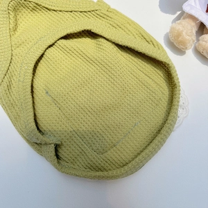 Detailaufnahme des avocadogrünen Waffelstrickstoffs und der Naht am Haustier-Latz