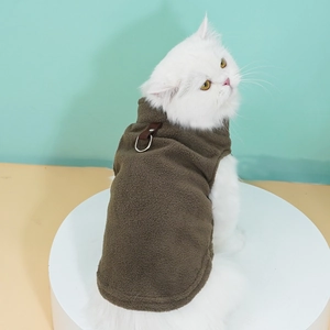Detailed view of brown fleece pet vest with metal D-ring harness on a white cat