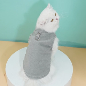 Close-up of light gray fleece pet vest with metal D-ring for leash on white fluffy cat