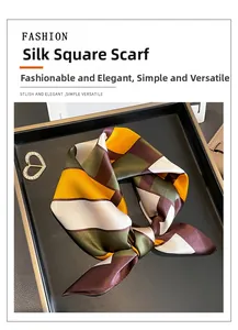 Detail of a color-block silk scarf with a heart-shaped diamond-studded gold brooch