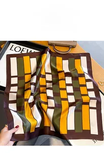 Detailed close-up of geometric pattern luxury silk scarf on a wooden texture background
