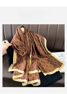 Detailed macro view of the silky satin texture and golden clover pattern on the brown scarf