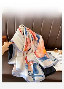 Close-up of floral print beach scarf with satin texture draped on a leather sofa