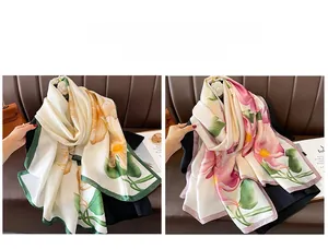 Detail view of two vintage floral print silk scarves with green and pink borders