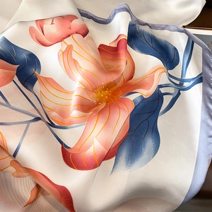 Macro detail of floral silk scarf featuring soft gradients and elegant purple rolled edges