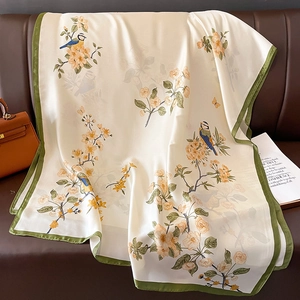 Detail of silk-feel scarf with bird and floral print featuring elegant green piping edges