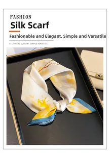Silk neckerchief tied on a black tray next to a leather bag for elegant office style