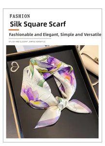 Detail of silk square scarf with purple and yellow iris floral print on a tray