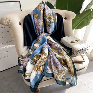 Baroque floral silk scarf with golden and sky blue prints draped on a vintage chair