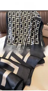 Detailed view of the neat overlock stitching and smooth silk-like texture of the geometric scarf