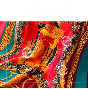 Detail of baroque silk scarf with gold chain patterns and smooth satin texture