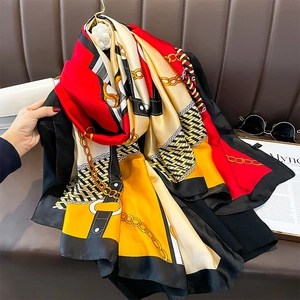 Sciarpa di seta estiva alla moda con stampe geometriche e catene d'oro appesa a un gancio