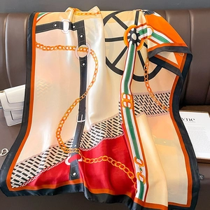 Dettaglio di un elegante foulard in seta con motivi geometrici equestri e catene