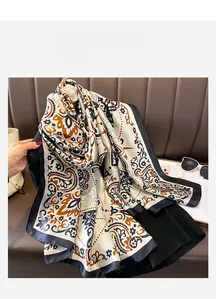 Dettaglio di un foulard in seta paisley con bordo blu e motivi floreali vintage